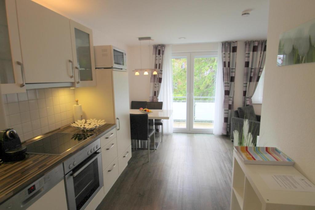 a kitchen with white cabinets and a table and aearcherswersswersswers at 1010 - Seesternweg 4 - OG in Dahme
