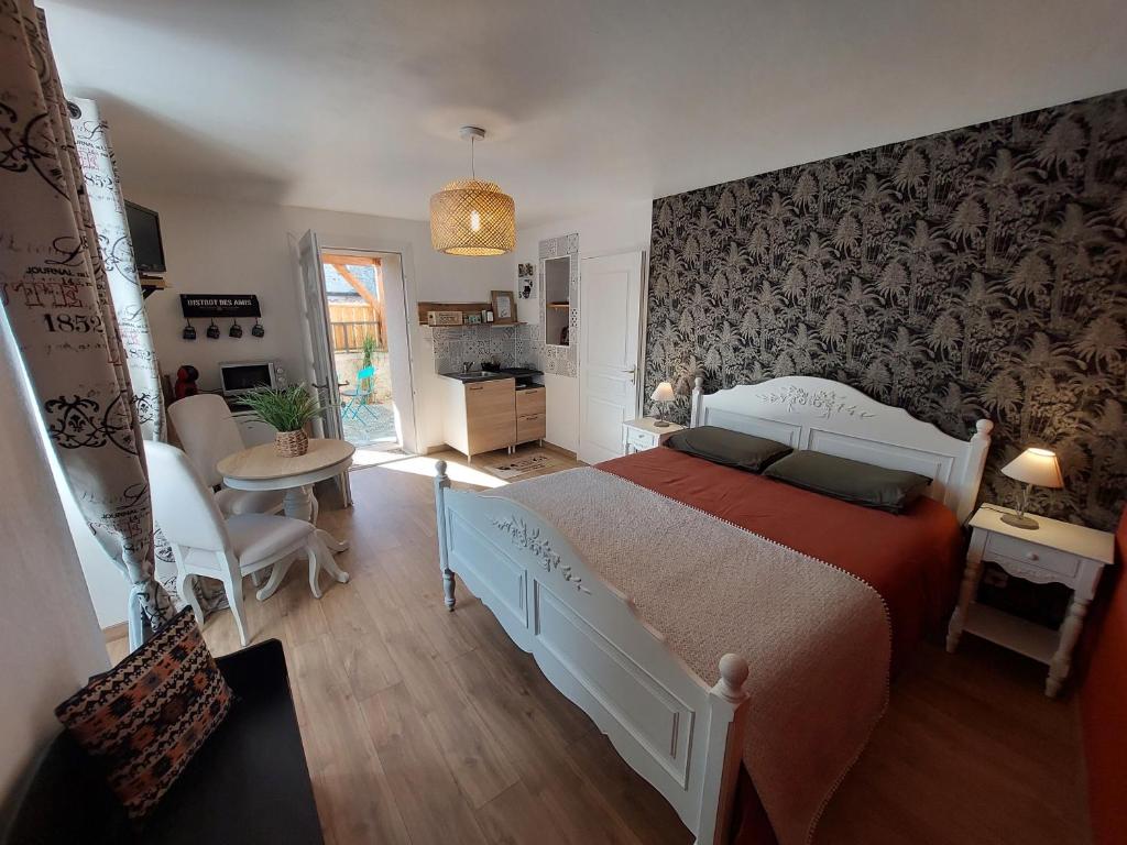 1 dormitorio con 1 cama grande y comedor en Les Petits Jardins de Cissé Chambre de Charme, en Cissé