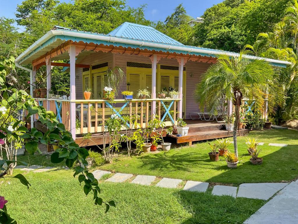 mały dom z gankiem i roślinami w obiekcie Villa Caribbean Dream w mieście Vieux Fort