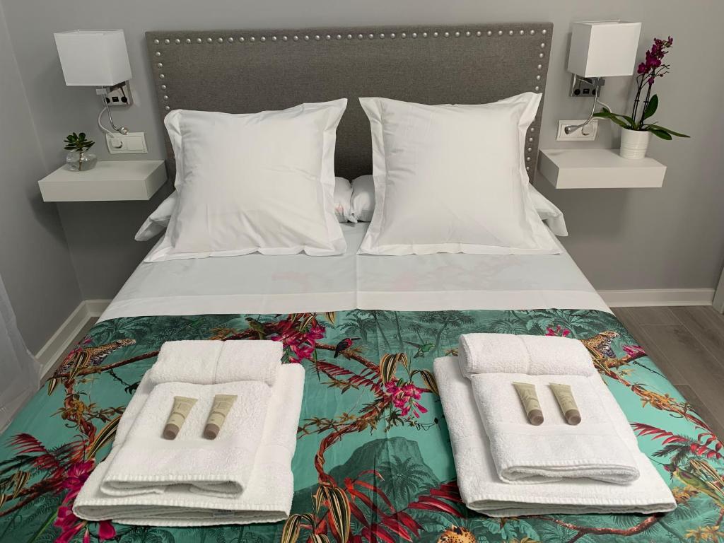 a bedroom with a bed with two towels on it at Kentia Rooms Torremolinos in Torremolinos