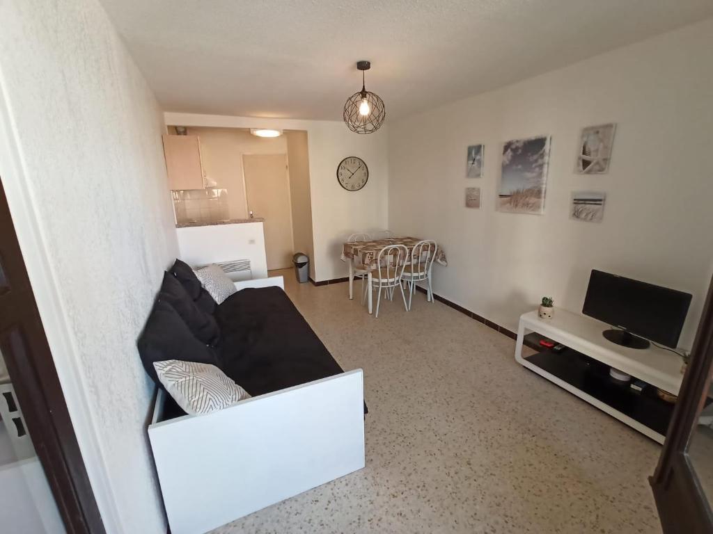 un salon avec un canapé blanc et une cuisine dans l'établissement Cap d agde 200m plage du môle accès direct aux rues piétonnes, au Cap d'Agde