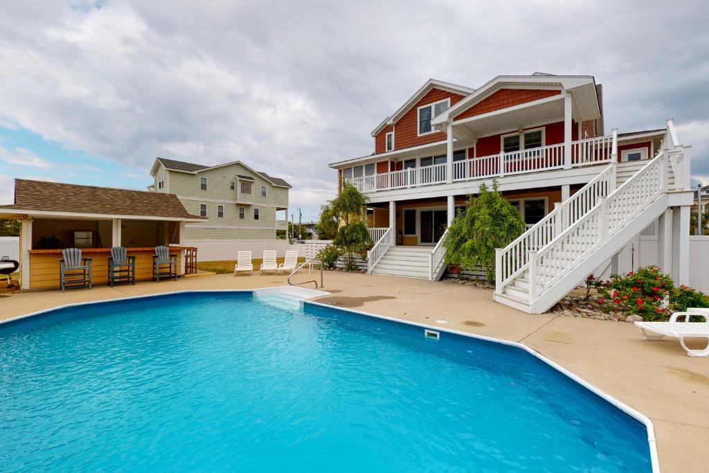 a house with a swimming pool in front of a house at Dreamweaver in Virginia Beach