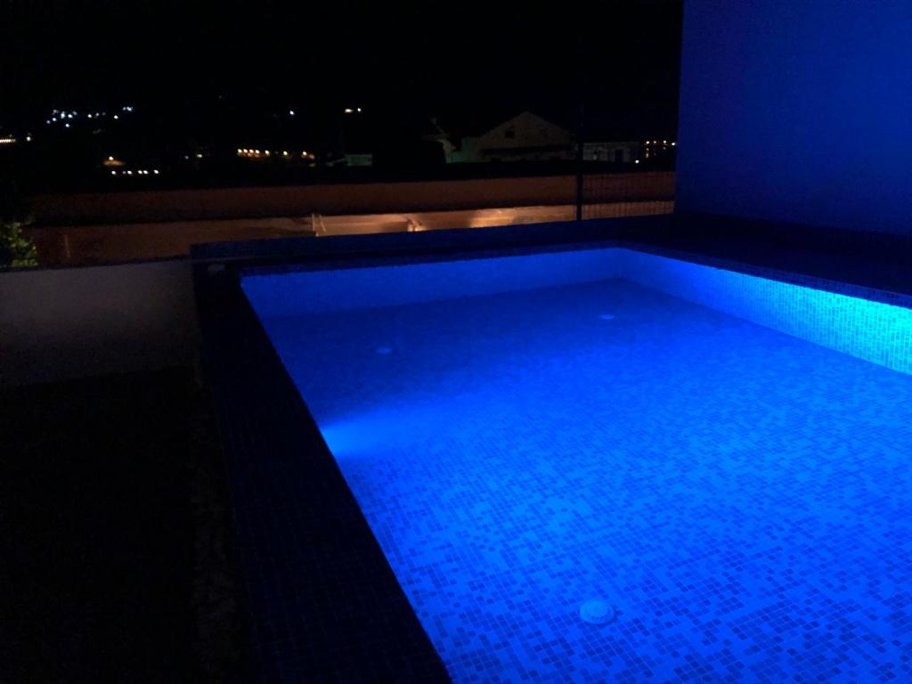 duży basen z niebieskim oświetleniem w nocy w obiekcie METROPOLIS Argostoli House/villa with garden & pool-jacuzzi w mieście Argostoli