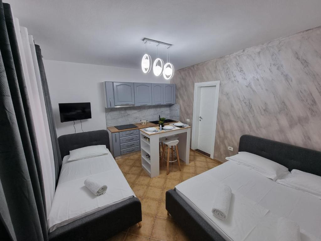 Habitación pequeña con 2 camas y escritorio. en Studio Vlora, en Vlorë