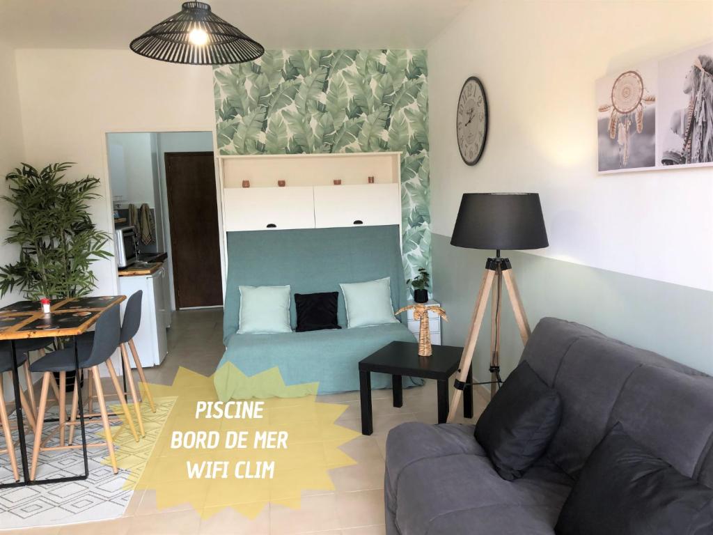 een woonkamer met een bank en een bed bij Studio bord de mer - Plage - Piscine - Wifi in Santa-Lucia-di-Moriani