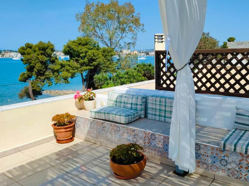 een bank op een balkon met uitzicht op het water bij Sea Breeze - Home with a View in Bouzéïka