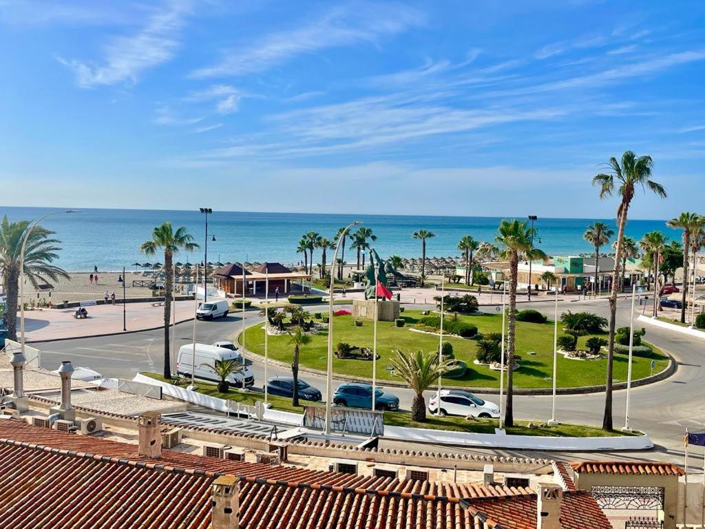 uma vista para um parque de estacionamento com palmeiras e o oceano em JAZMÍN DEL MAR em Torremolinos