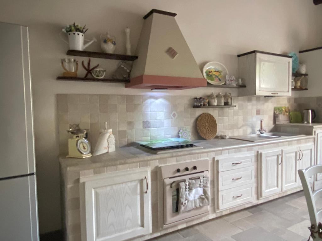 cocina con fregadero y fogones horno superior en La casetta di campagna, en Buseto Palizzolo