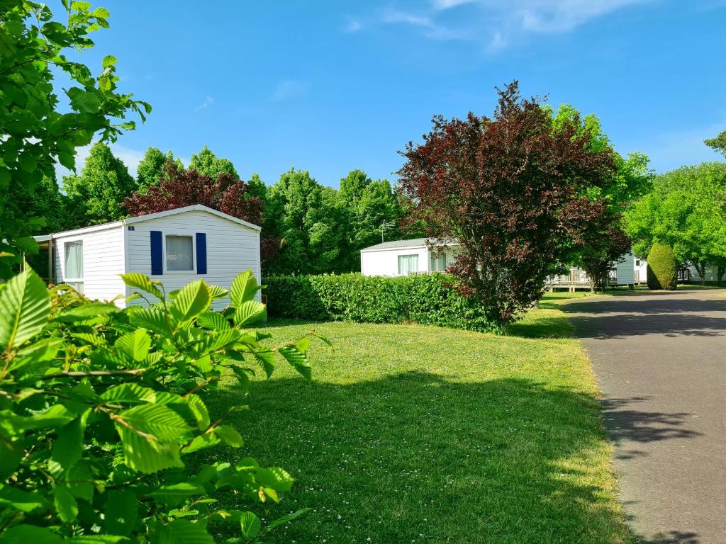 een tuin met een wit huis en bomen bij Resort & Camping - Val de Braye in Bessé-sur-Braye