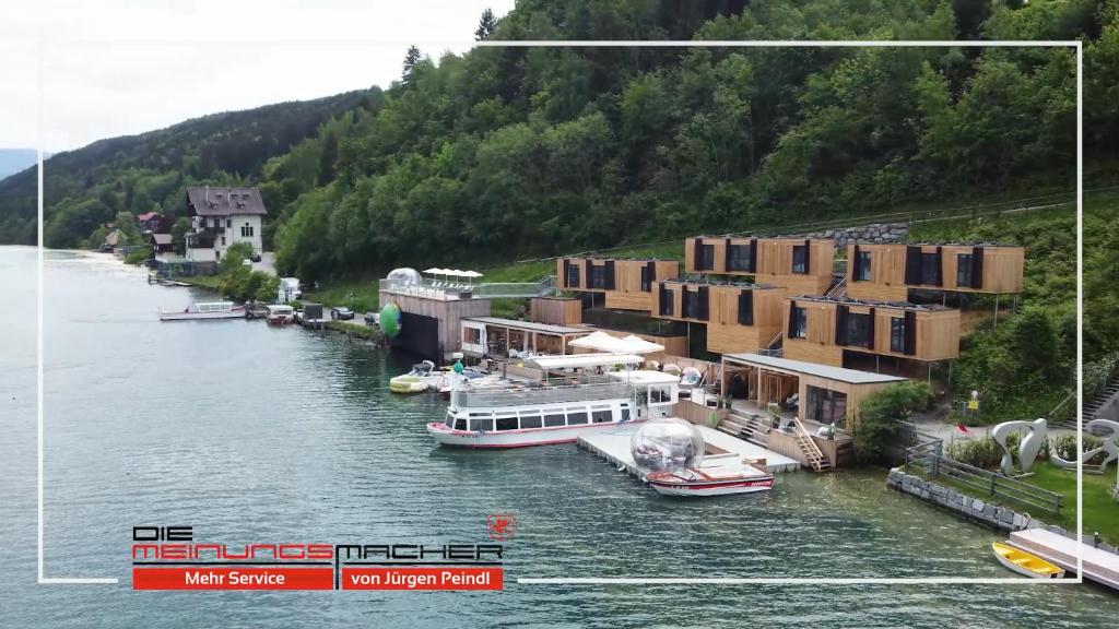 un río con casas y barcos en el agua en Kantor Lodges & Chalets, en Millstatt