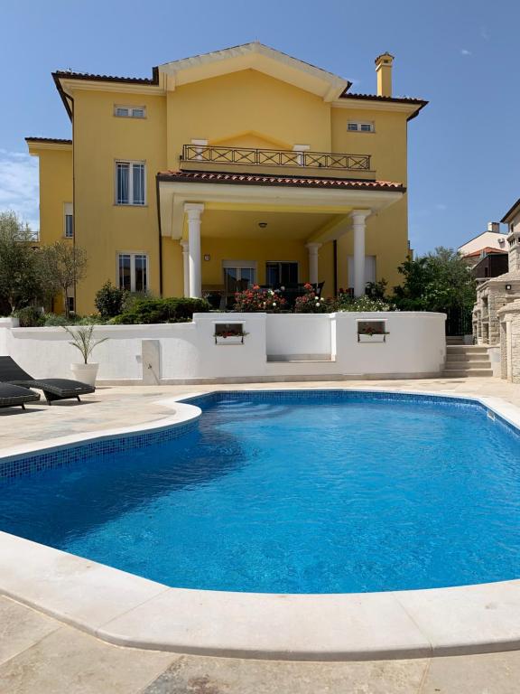 a large swimming pool in front of a house at Villa Istriana in Ližnjan