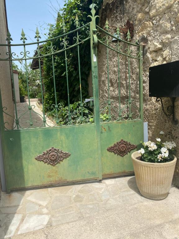a green gate with a plant in a pot at Lou Mut in Lectoure