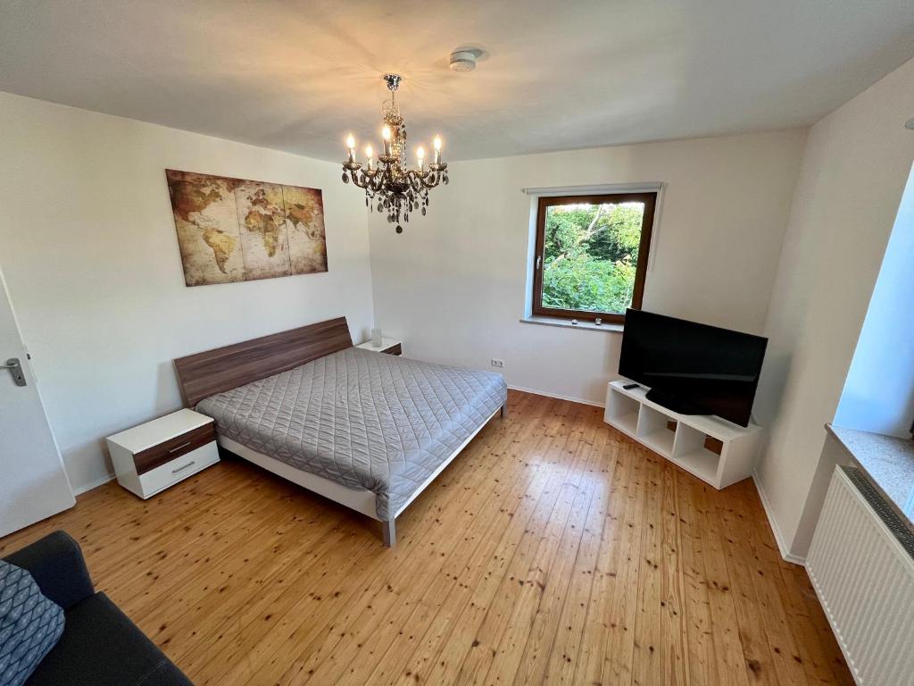 een slaapkamer met een bed en een kroonluchter bij Ferienwohnung am Staffelsberg in Bad Kissingen