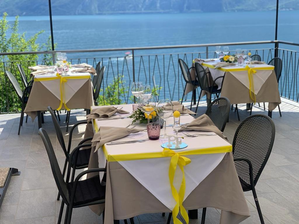 eine Gruppe von Tischen mit gelben Schalen darauf in der Unterkunft Hotel Alla Noce in Limone sul Garda