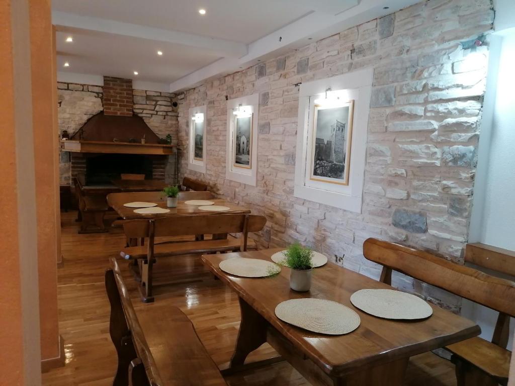 une salle à manger avec des tables en bois et un piano dans l'établissement Apartments and pansion M&R, à Turanj