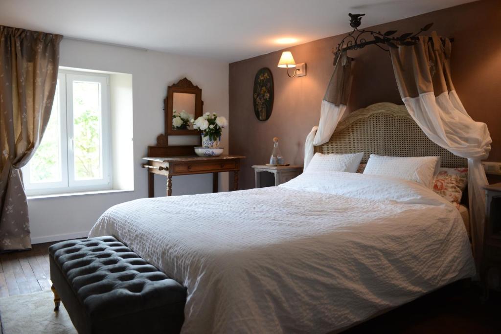 a bedroom with a large bed and a window at Le Nid de Louppy in Louppy-sur-Loison