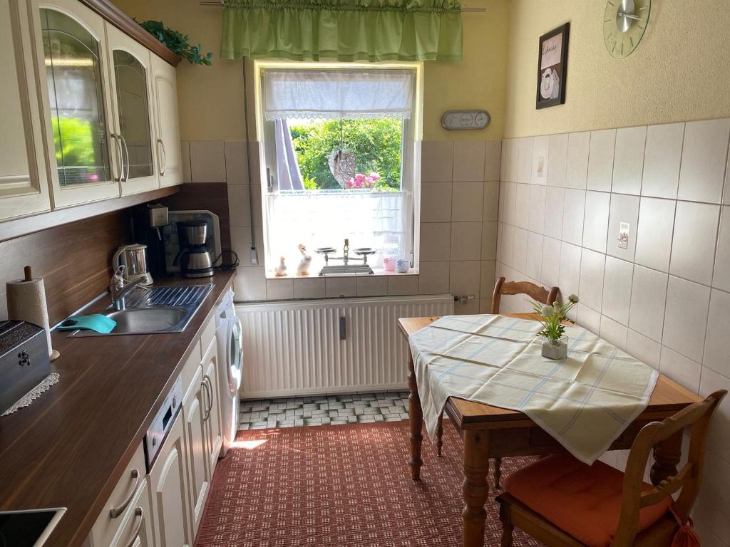 una cucina con tavolo, lavandino e finestra di Ferien-/Monteurwohnung Linge (Marienheide) a Marienheide