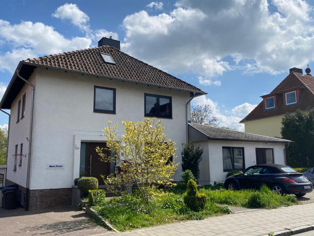 a white house with a car parked in front of it at Haus Potosi, Travemünde in Lübeck