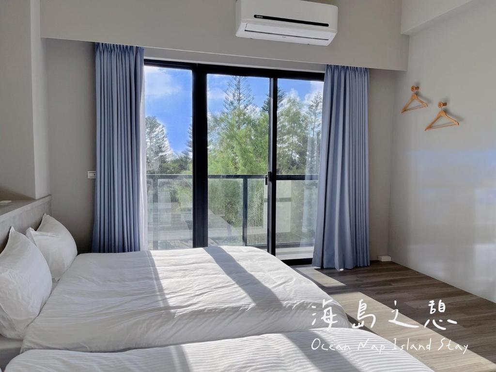 - une chambre avec un lit et une grande fenêtre dans l'établissement Ocean Nap Island Stay, à Magong