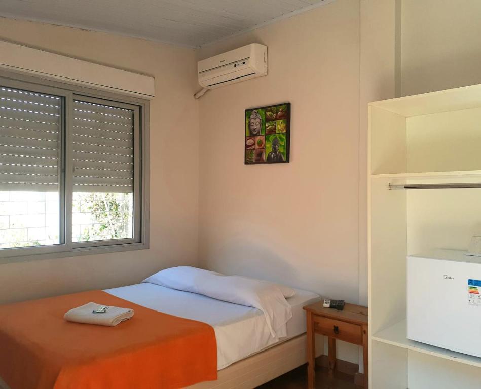 a small bedroom with a bed and a window at Pousada Terra Sul in Porto Alegre