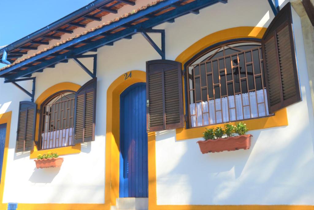 um edifício branco com janelas e plantas em Marujo Hostel em Ubatuba