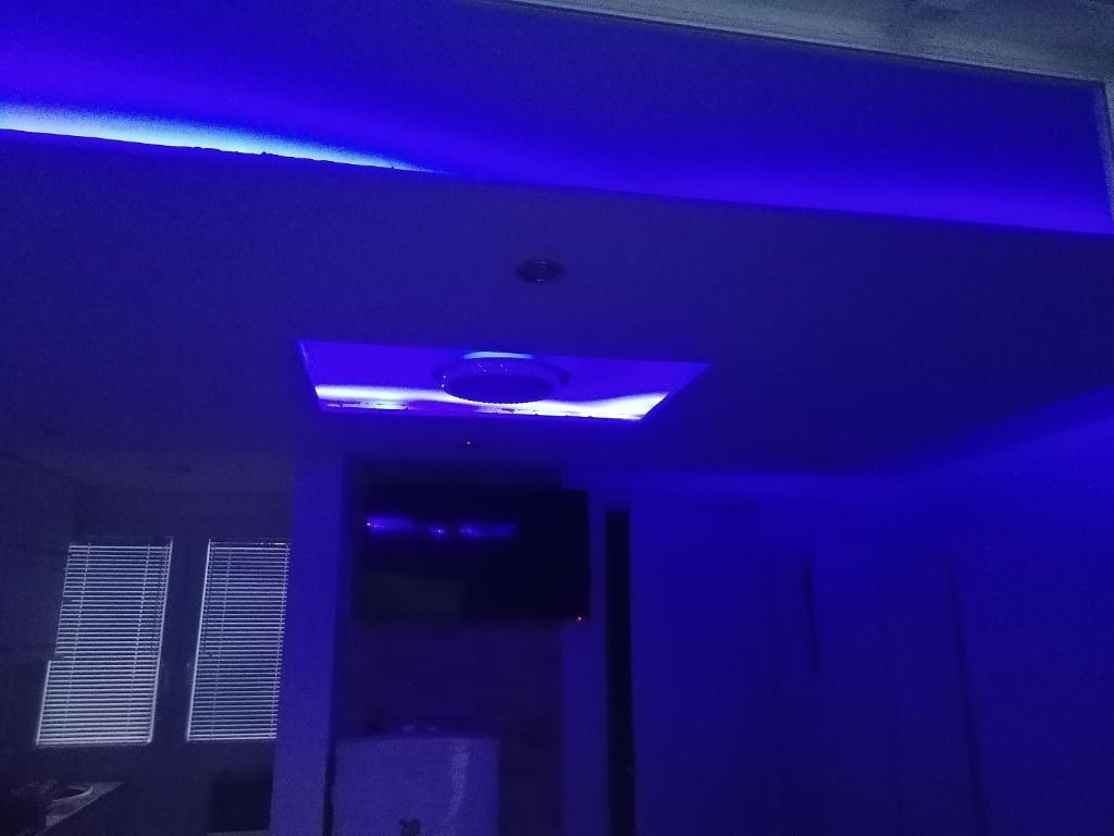 niebieski sufit z niebieskim światłem w pokoju w obiekcie Aqua Bella Apartman w Segedynie