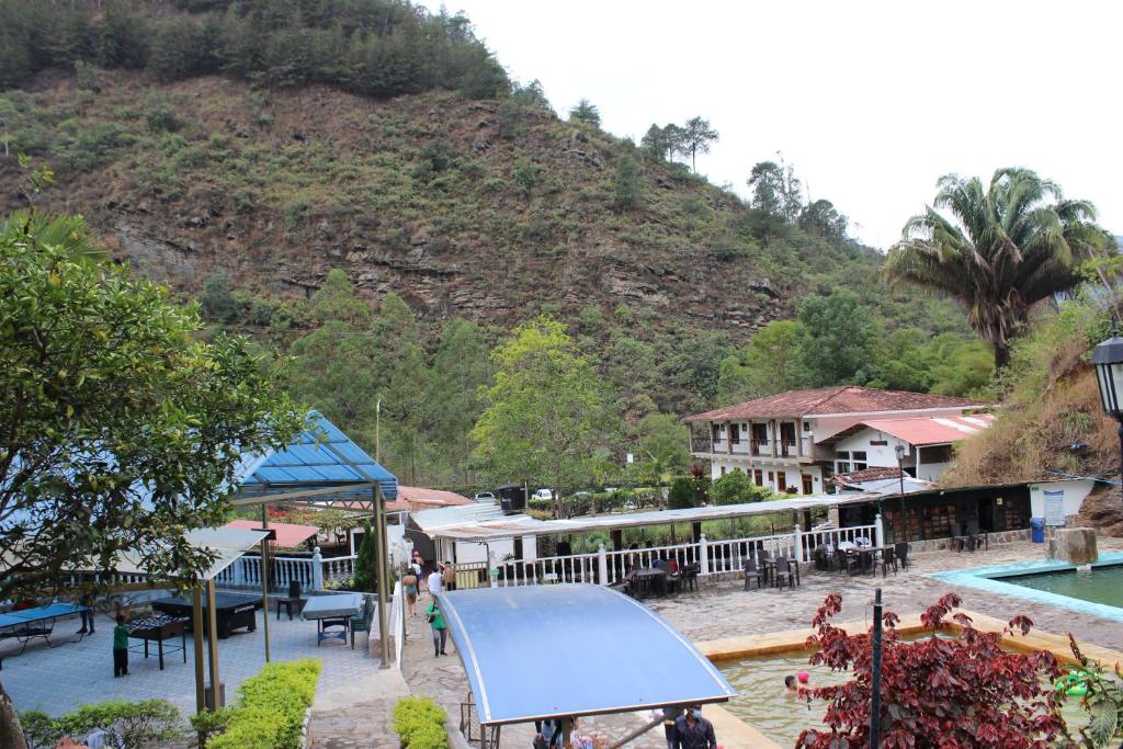 a resort with a swimming pool and a mountain at Centro Vacacional Paraiso Termal in Tibirita