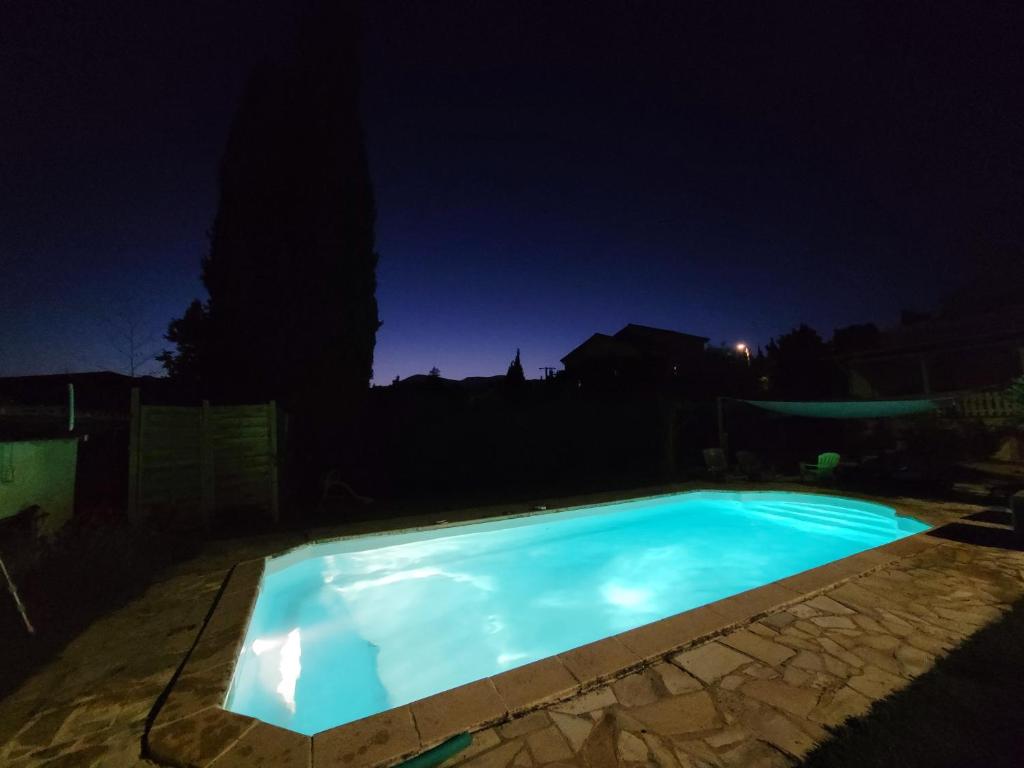 a swimming pool lit up at night at Laura & Paul in La Colle-sur-Loup
