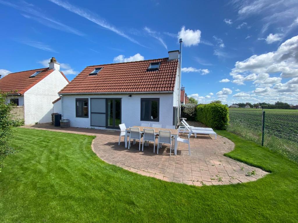 a house with a table and chairs in the yard at Charlie & Chloé’s beachcondo ***** in De Haan