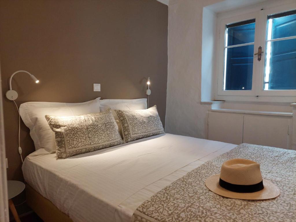 a bedroom with a bed with a hat on it at G-House of Tinos in Tinos Town