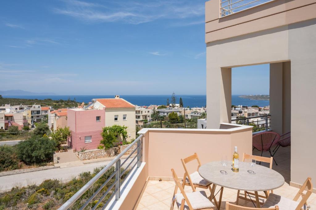 balcone con tavolo, sedie e vista sulla città di Fantasea Unique Resort a Kalathas