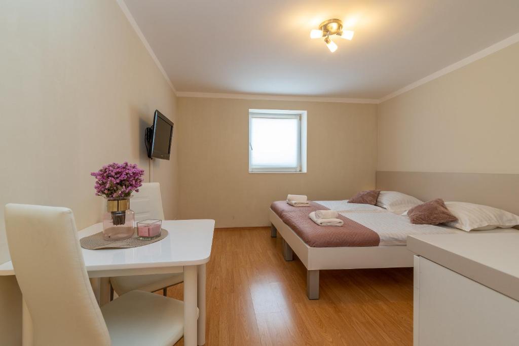 a bedroom with a bed and a table and a desk at Apartments Leonarda in Trogir