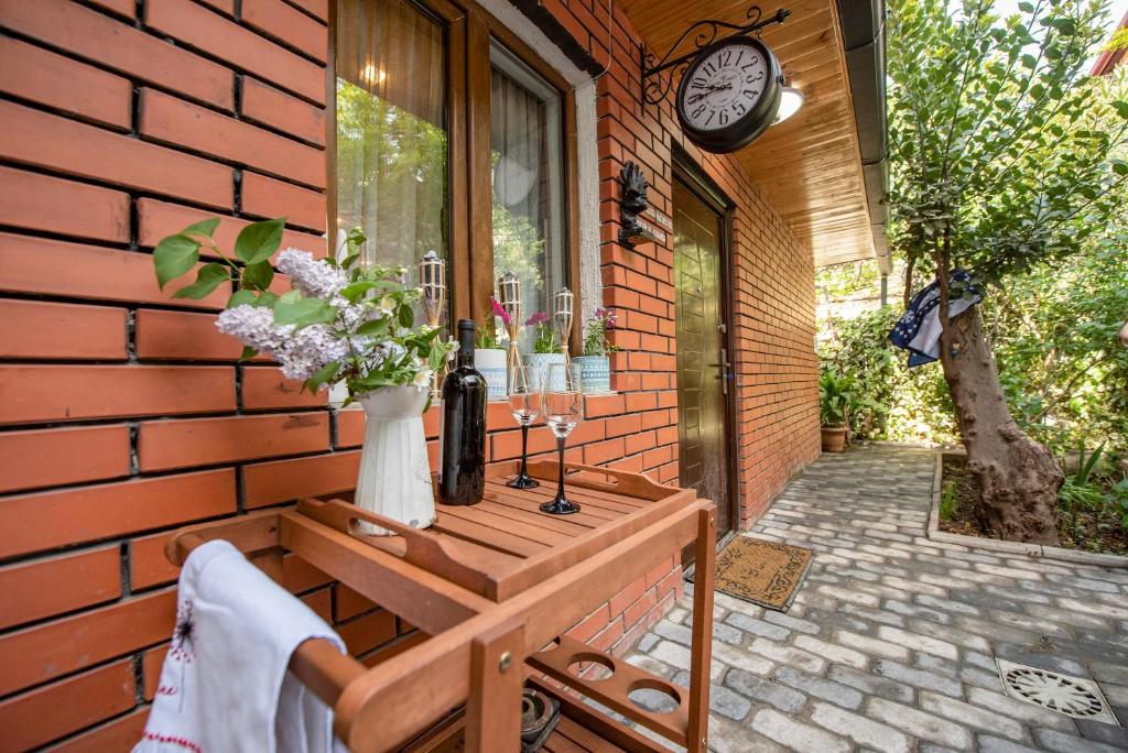 un banco en el costado de una casa con un reloj en Garden House en Tiflis