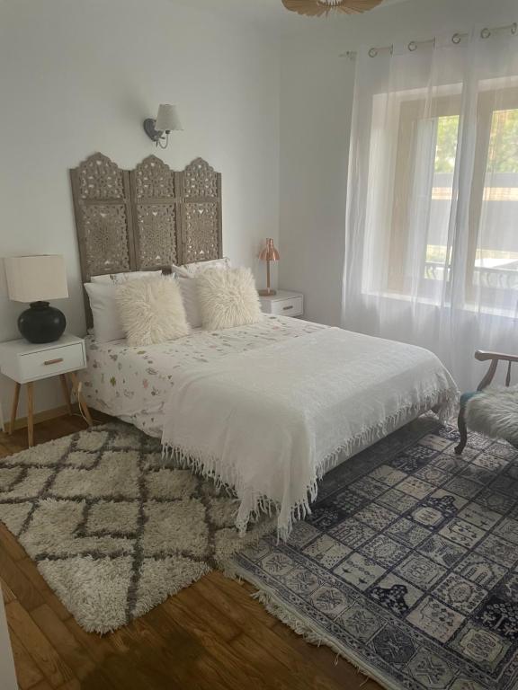 Cette chambre comprend un grand lit avec des draps blancs et un tapis. dans l'établissement Chez Souka, à Carcassonne