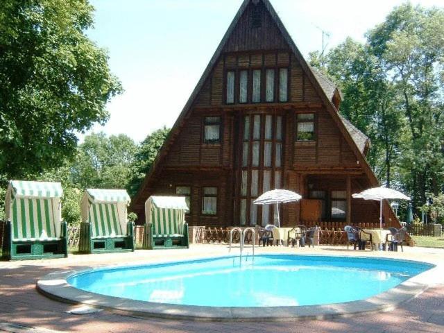 a house with a swimming pool in front of it at Ferienpark Rosstrappe in Thale