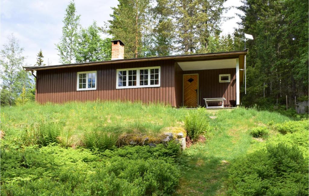 a small house in the middle of a field at Awesome Home In Hurdal With 2 Bedrooms in Hurdal