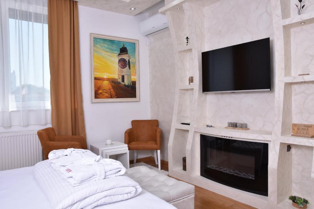 a hotel room with a fireplace and a tv on a wall at Frajla in Novi Sad