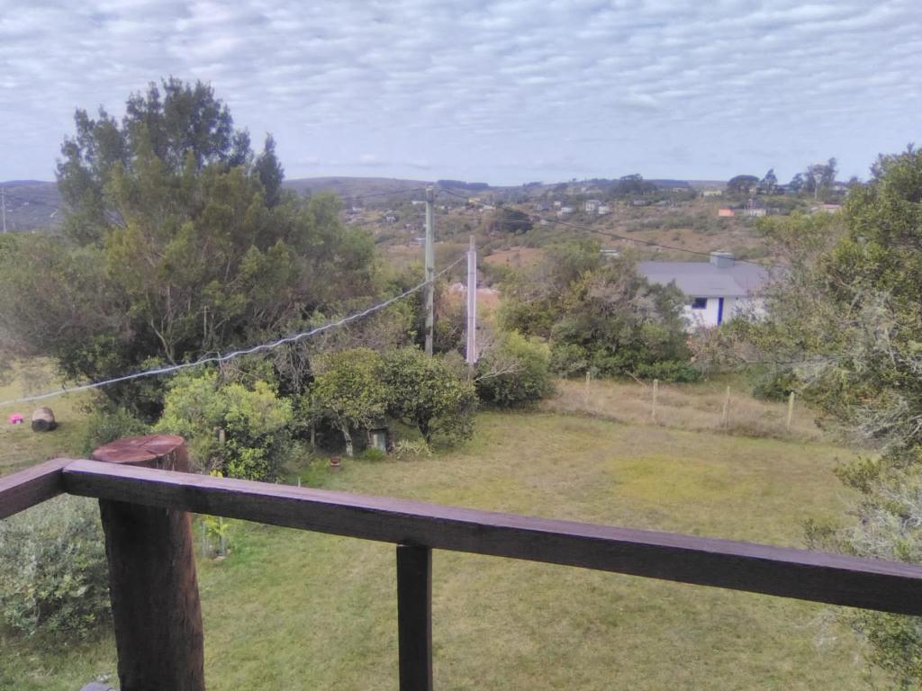 a view from the balcony of a house with a yard at Horneritos - Cabaña en Villa Serrana in Villa Serrana