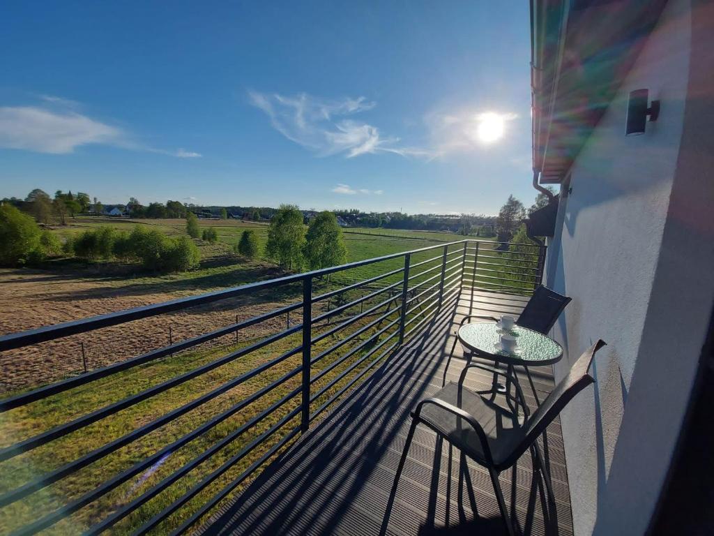 a balcony with a table and a view of a field at Słoneczny Zakątek Sominy in Sominy