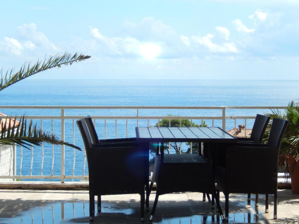 una mesa y sillas en un balcón con vistas al océano en Amazing sea view apartments, en Dubrovnik