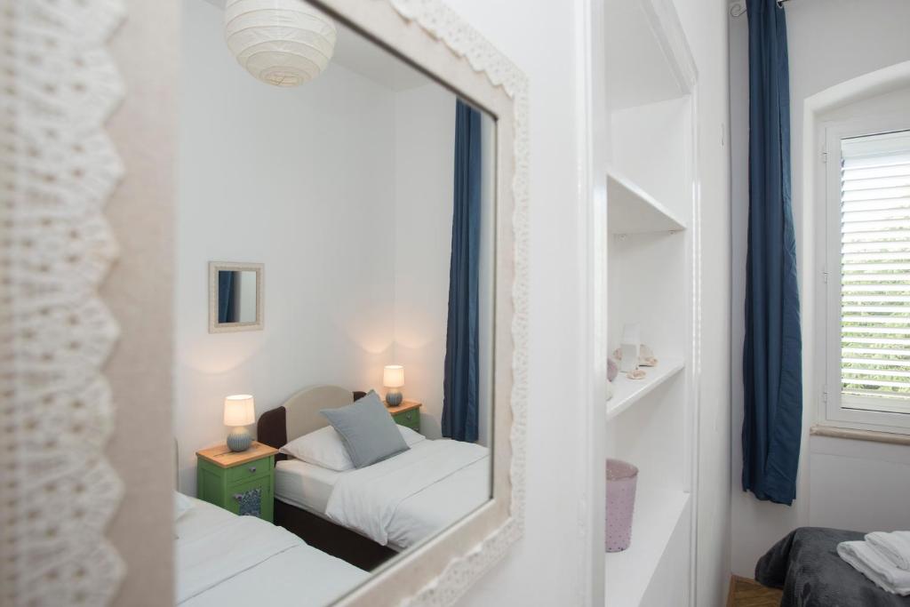 a mirror in a room with a bed and a couch at Town Place Apartment in Split