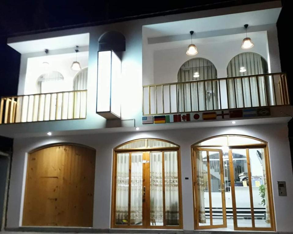 een gebouw met drie deuren en een balkon bij Hostal Mendieta in Paracas