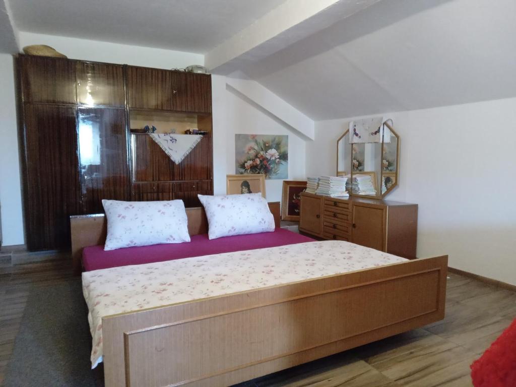 a bedroom with a large bed and a mirror at GM - Studio Apartment in Trebinje