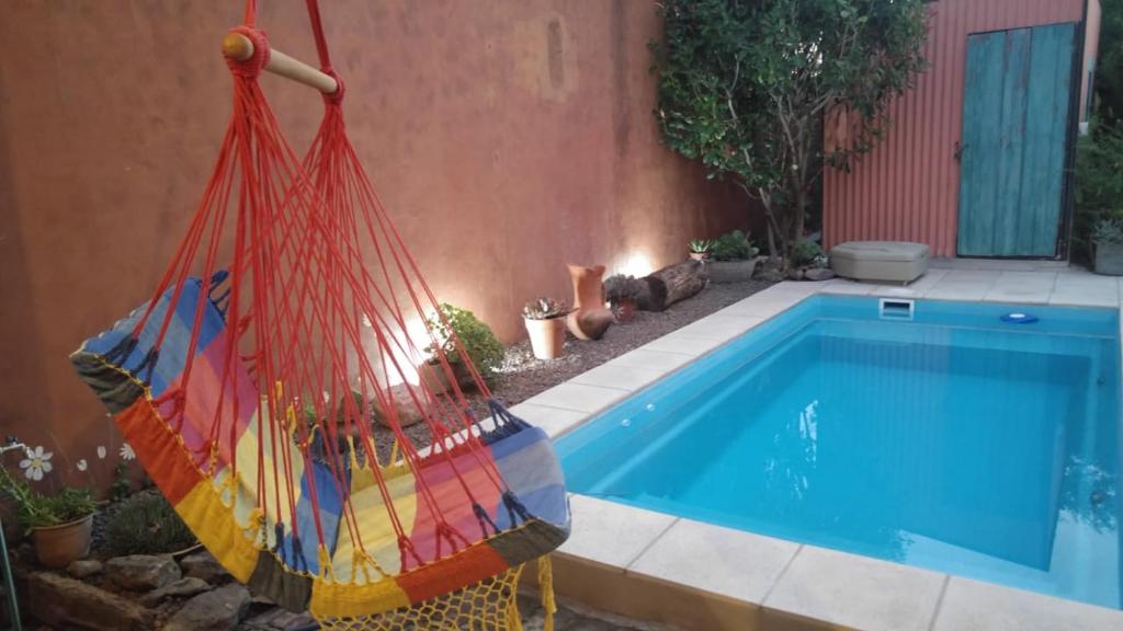 a colorful hammock is next to a swimming pool at Pampa y Saboya in Villa Elisa