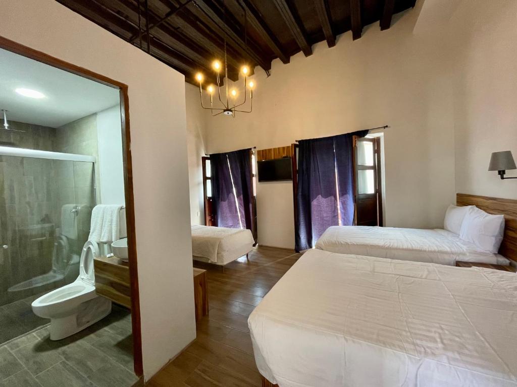 - une chambre avec deux lits et une salle de bains avec un miroir dans l'établissement Palacio de las Rosas, à Durango