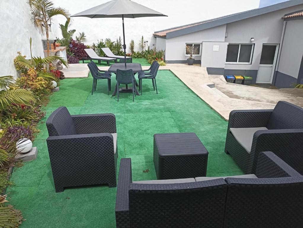 patio con sedie, tavolo e ombrellone di Janela Mar Garden a Lagoa