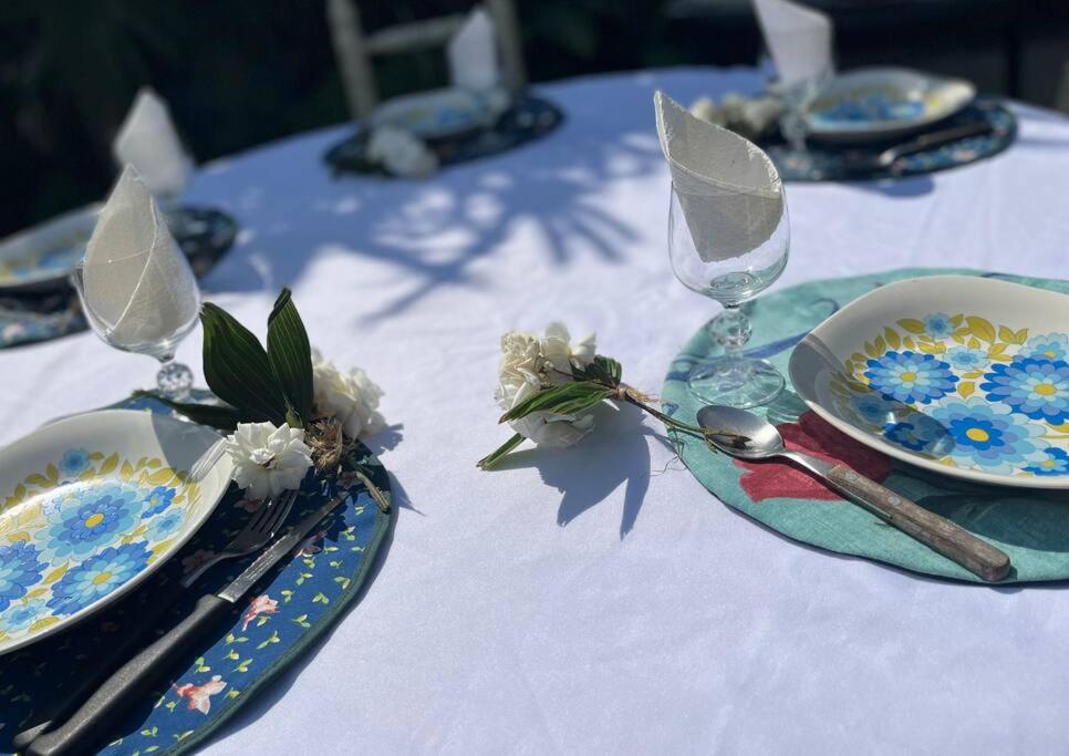 a table with plates and glasses on a white table cloth at Casa de Huéspedes La Escondida in Yerba Buena