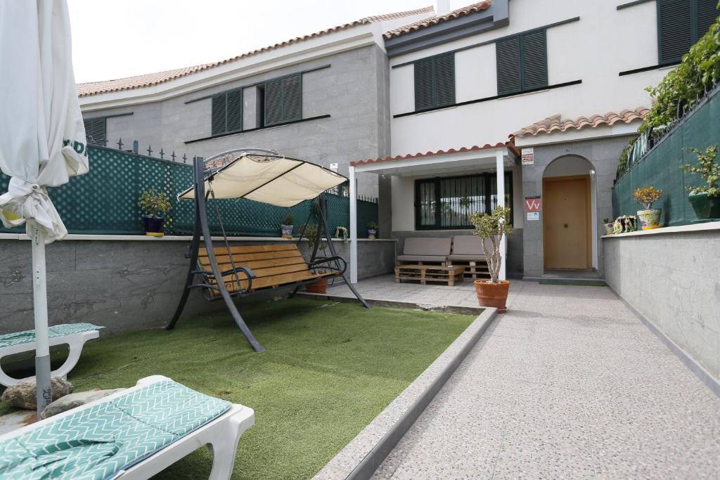 un patio con banco y sombrilla en Masvacation Calle Lanzarote B, 4Room, Terrace en Playa del Ingles