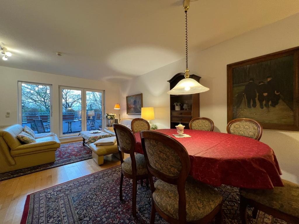 une salle à manger avec une table et des chaises rouges dans l'établissement Maisonette Penthouse für 8 Personen by Rabe - free Netflix & kostenloser Parkplatz & große Terrasse, à Karlsruhe