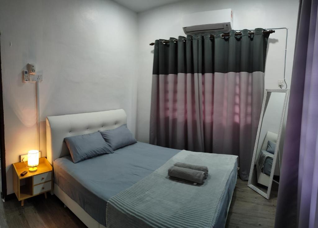 - une petite chambre avec un lit et un miroir dans l'établissement DARUL AMAN Homestay Jitra, à Jitra